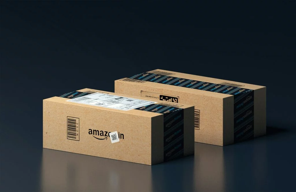 Two Amazon delivery boxes placed against a black background. This image symbolizes the increasing volume of shipments associated with Amazon sales growth, reflecting the rising demand for products from the platform.