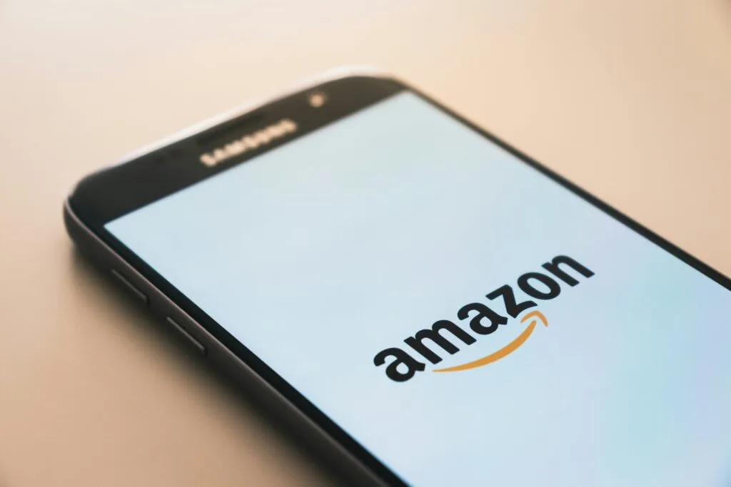 Amazon logo displayed on a mobile phone, emphasizing the implications of the platform for Shopify eco-tech innovations in local markets.