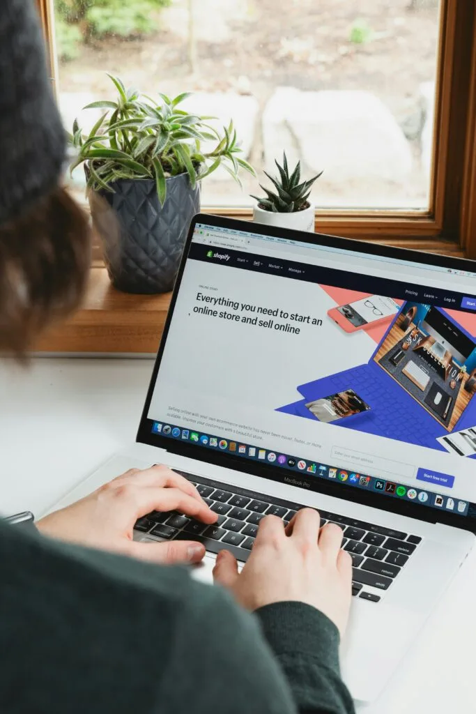 Woman using a laptop with Shopify open, highlighting the platform's eco-tech innovations in eCommerce.