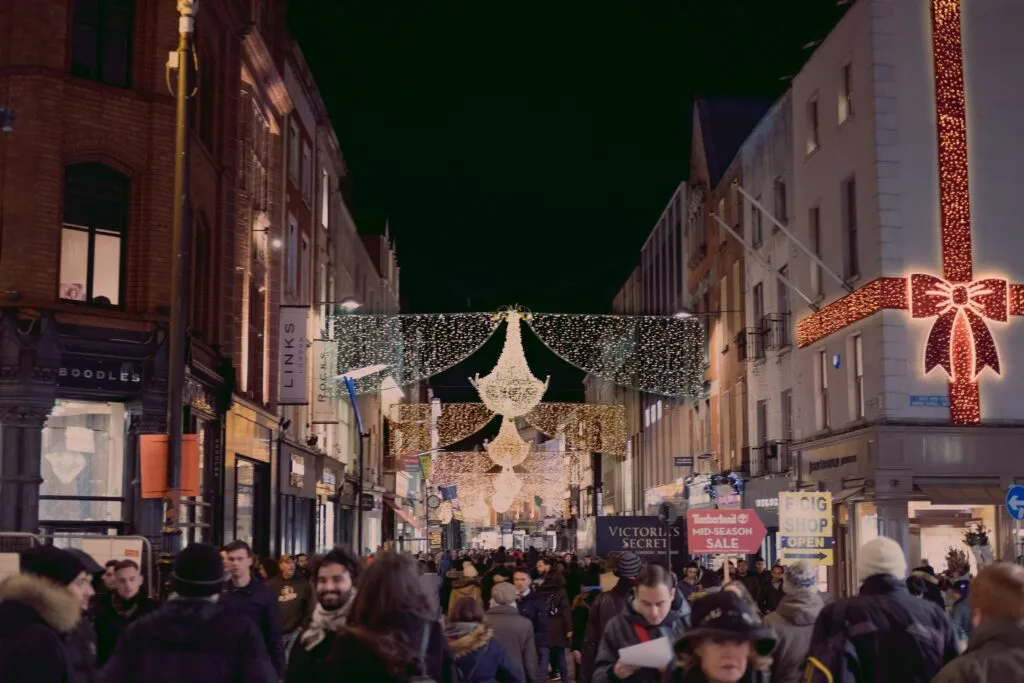 A bustling street adorned with festive holiday decorations, filled with shoppers and vibrant displays. This image captures the essence of TikTok eCommerce marketing during the holiday season, reflecting the evolving trends and strategies that drive impactful sales during this festive time.