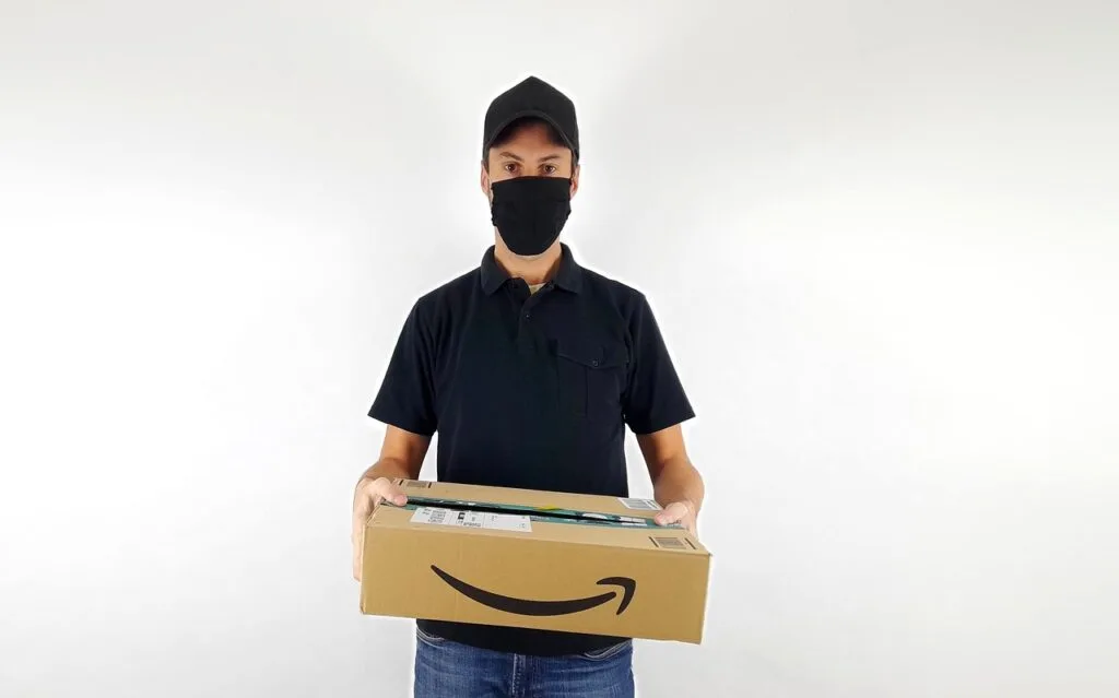 An individual holding an Amazon box, showcasing the latest shift in Amazon Haul strategy as part of the ongoing trends in eCommerce. This change highlights significant updates and moves across major platforms in the industry.