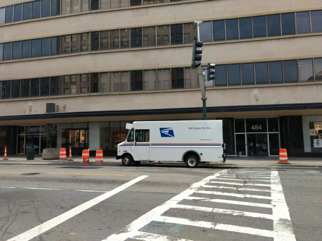A USPS truck on the street, symbolizing the complexities of eCommerce shipping and the innovative strategies, including the Amazon Haul strategy, aimed at improving logistics and environmental impact.