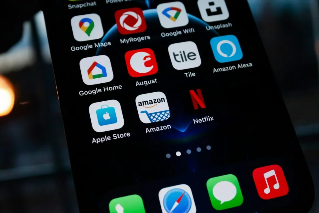Smartphone screen displaying Amazon app alongside other popular apps, highlighting policy changes relevant to small businesses on the Amazon platform.
