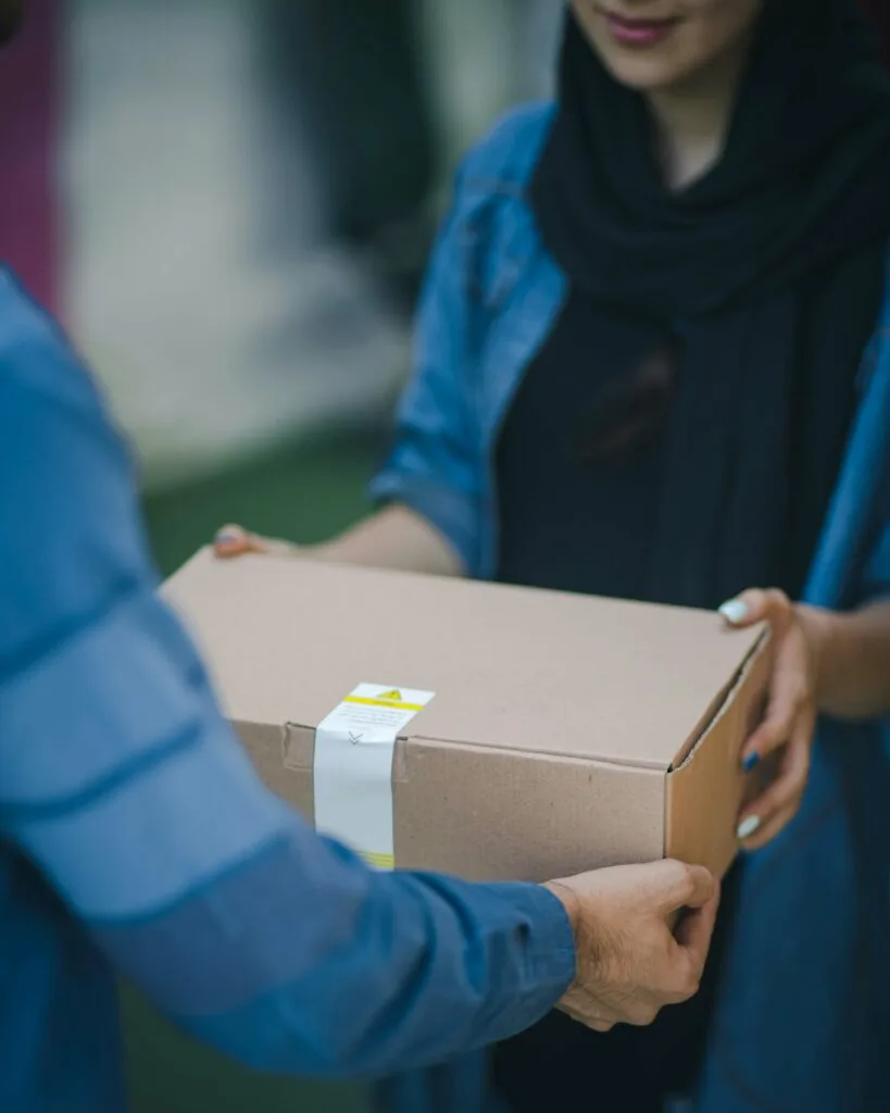 A woman happily receiving a package, symbolizing Amazon eCommerce strategies focused on customer retention, loyalty, and exclusive Prime perks.