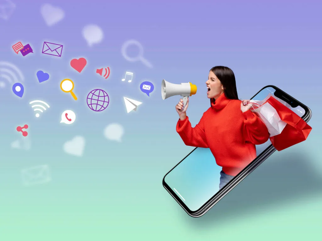 Amazon eCommerce strategies depicted with a woman emerging from a smartphone, holding shopping bags and a megaphone, surrounded by digital marketing icons, symbolizing high-tech advertising in eCommerce.