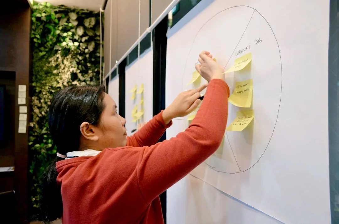 Person arranging sticky notes on a circular chart; illustrates UX vs. CRO strategies in eCommerce.