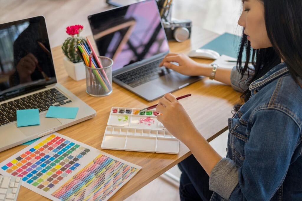 Image of young woman working on Voice of the Customer Initiatives, implementing art pieces into their campaigns